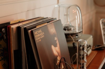 Chambre avec lit double, mur décoré de motifs géométriques bleus et blancs, lumière naturelle entrant par une fenêtre.