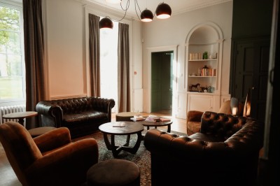 Chambre avec lit double, mur décoré de motifs géométriques bleus et blancs, lumière naturelle entrant par une fenêtre.