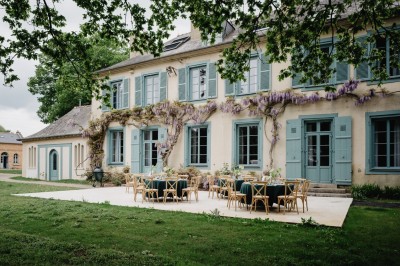 Chambre avec lit double, mur décoré de motifs géométriques bleus et blancs, lumière naturelle entrant par une fenêtre.