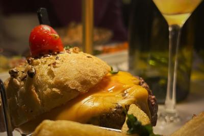 Plateau de canapés variés avec légumes, olives et garnitures, disposé sur une table ronde dans une salle de réception.