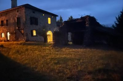 Salle de bain avec deux lavabos sur pied, une douche vitrée et des murs en pierre apparente.