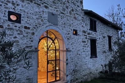 Salle de bain avec deux lavabos sur pied, une douche vitrée et des murs en pierre apparente.