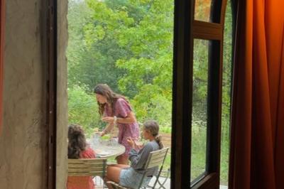 Salle de bain avec deux lavabos sur pied, une douche vitrée et des murs en pierre apparente.