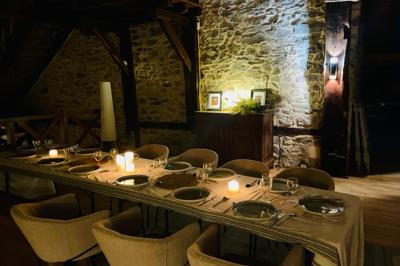 Salle de bain avec deux lavabos sur pied, une douche vitrée et des murs en pierre apparente.