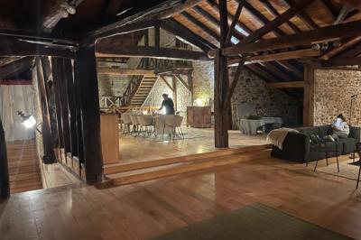 Salle de bain avec deux lavabos sur pied, une douche vitrée et des murs en pierre apparente.
