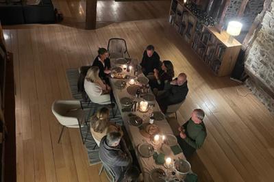 Salle de bain avec deux lavabos sur pied, une douche vitrée et des murs en pierre apparente.