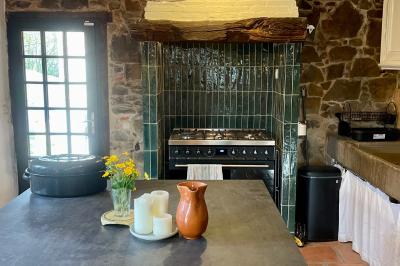 Salle de bain avec deux lavabos sur pied, une douche vitrée et des murs en pierre apparente.