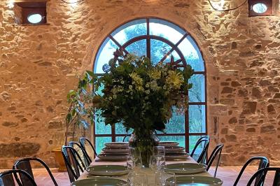 Salle de bain avec deux lavabos sur pied, une douche vitrée et des murs en pierre apparente.