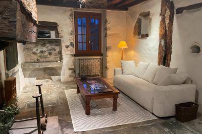 Salle de bain avec deux lavabos sur pied, une douche vitrée et des murs en pierre apparente.