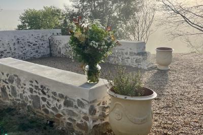 Salle de bain avec deux lavabos sur pied, une douche vitrée et des murs en pierre apparente.