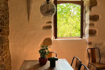 Salle de bain avec deux lavabos sur pied, une douche vitrée et des murs en pierre apparente.