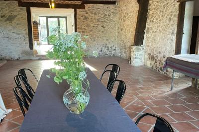 Salle de bain avec deux lavabos sur pied, une douche vitrée et des murs en pierre apparente.