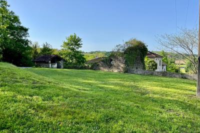 Salle de bain avec deux lavabos sur pied, une douche vitrée et des murs en pierre apparente.