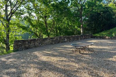 Salle de bain avec deux lavabos sur pied, une douche vitrée et des murs en pierre apparente.