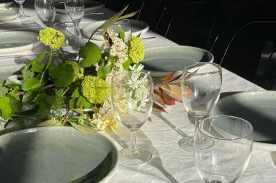 Salle de bain avec deux lavabos sur pied, une douche vitrée et des murs en pierre apparente.
