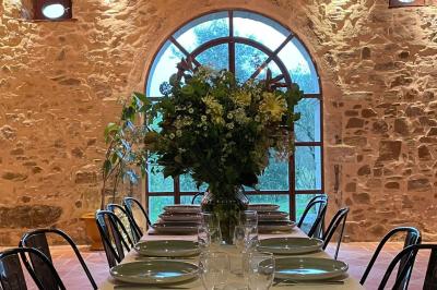 Salle de bain avec deux lavabos sur pied, une douche vitrée et des murs en pierre apparente.