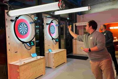 Deux cibles de fléchettes lumineuses dans un espace de loisirs intérieur, avec éclairage coloré et décorations modernes.