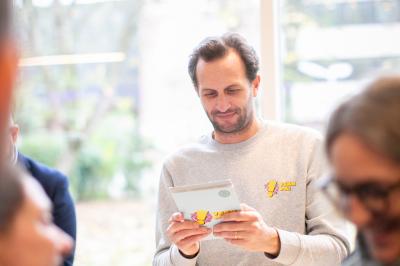 Des personnes jouent à un jeu de lancer de ballons de basket en plein air, entourées de spectateurs.