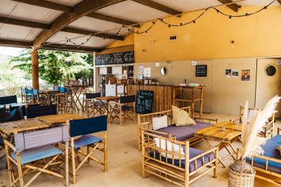 Rangée de lavabos avec miroirs dans une salle de bain aux murs blancs et carrelage vert et blanc.