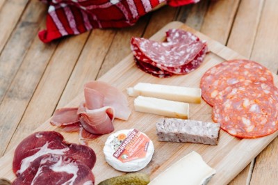 Deux personnes pratiquent le yoga en plein air sur des tapis, entourées de végétation.