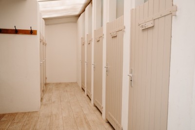 Deux personnes pratiquent le yoga en plein air sur des tapis, entourées de végétation.