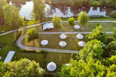 Intérieur d'une tente glamping avec un lit double, des meubles en bois et une ambiance lumineuse et chaleureuse.