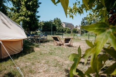 Miniature Location salle Cellettes (Loir-et-Cher) - Lodg’ing Nature Camp Châteaux de la Loire #8 Tentes blanches installées dans un espace naturel près d'une rivière, entourées d'arbres et d'un pont au coucher du soleil.