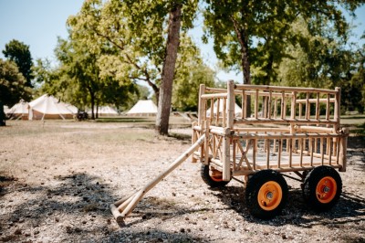 Miniature Location salle Cellettes (Loir-et-Cher) - Lodg’ing Nature Camp Châteaux de la Loire #17 Tentes blanches installées dans un espace naturel près d'une rivière, entourées d'arbres et d'un pont au coucher du soleil.