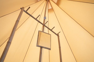 Miniature Location salle Cellettes (Loir-et-Cher) - Lodg’ing Nature Camp Châteaux de la Loire #18 Tentes blanches installées dans un espace naturel près d'une rivière, entourées d'arbres et d'un pont au coucher du soleil.