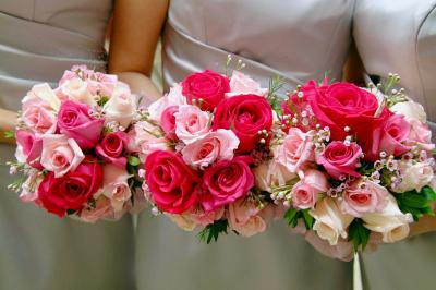 Jeune femme portant une couronne de fleurs blanches, vêtue de dentelle blanche, dans un jardin verdoyant.