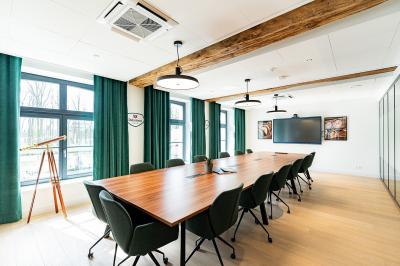 Un homme et une femme regardent une boîte dans un magasin de vins avec des étagères remplies de bouteilles en arrière-plan.