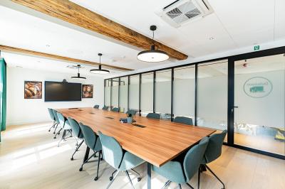 Un homme et une femme regardent une boîte dans un magasin de vins avec des étagères remplies de bouteilles en arrière-plan.