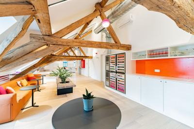 Un homme et une femme regardent une boîte dans un magasin de vins avec des étagères remplies de bouteilles en arrière-plan.