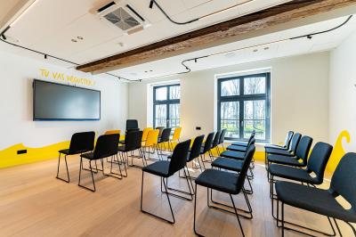 Un homme et une femme regardent une boîte dans un magasin de vins avec des étagères remplies de bouteilles en arrière-plan.