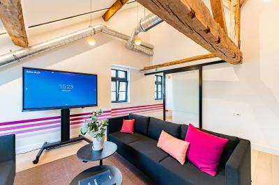 Un homme et une femme regardent une boîte dans un magasin de vins avec des étagères remplies de bouteilles en arrière-plan.
