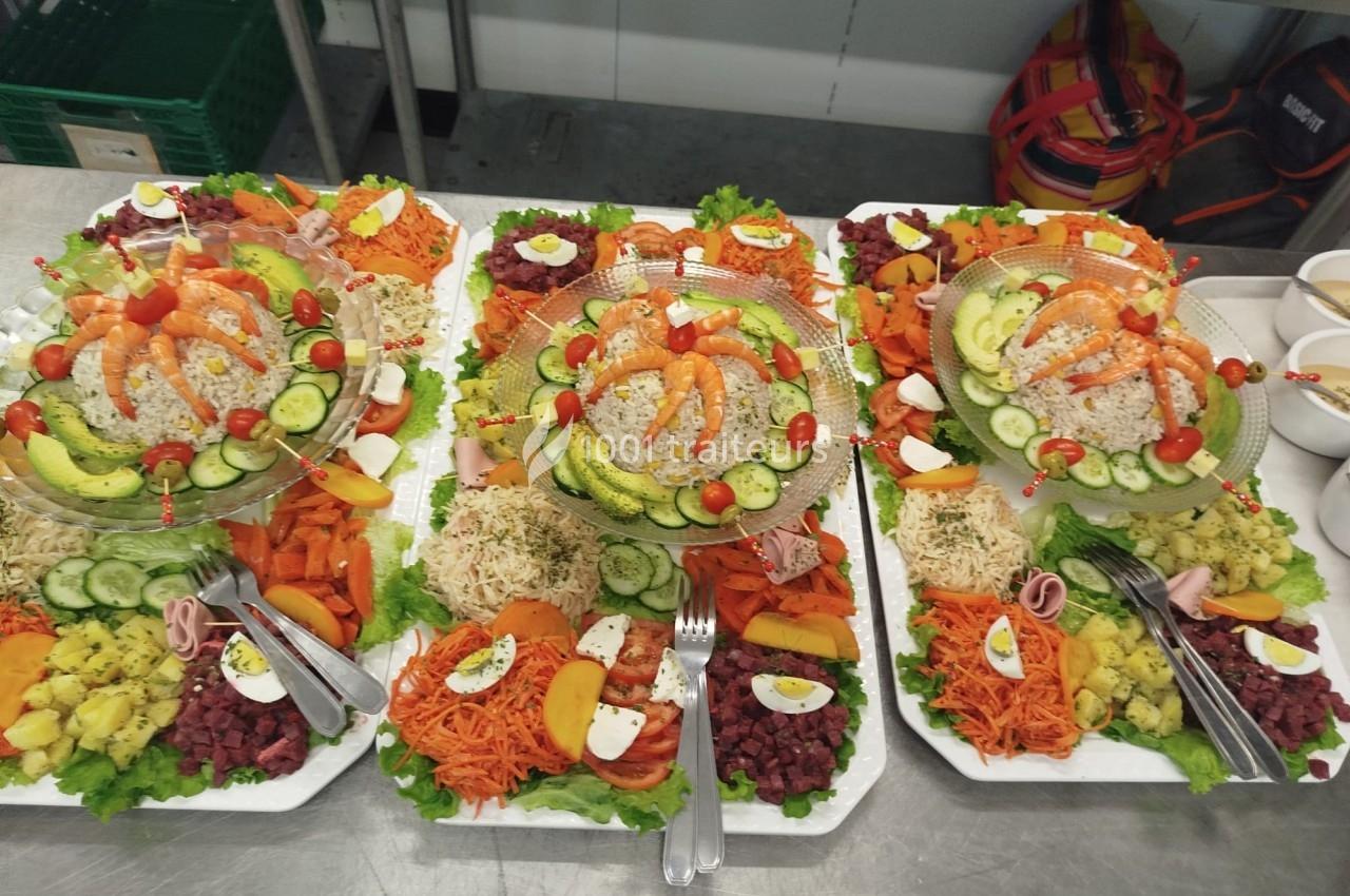 Plateaux garnis de crudités variées, riz, légumes frais, œufs durs et garnitures colorées disposés sur une table.