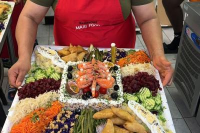 Buffet avec assortiments de sandwichs, samoussas, mini-burgers, canapés et coupes de fruits sur une table blanche.