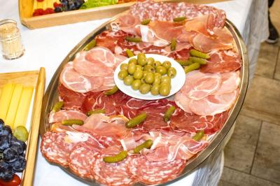 Buffet avec assortiments de sandwichs, samoussas, mini-burgers, canapés et coupes de fruits sur une table blanche.