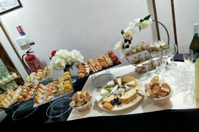 Plateau circulaire avec des pâtisseries miniatures, entouré de divers amuse-bouches et desserts sur une table.