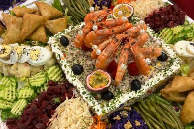 Plateau circulaire avec des pâtisseries miniatures, entouré de divers amuse-bouches et desserts sur une table.