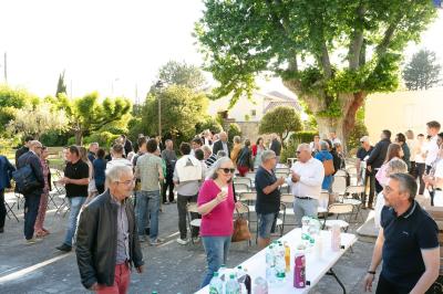 Paysage au crépuscule avec silhouettes de collines, arbres et habitations sous un ciel dégradé du bleu à l'orange.
