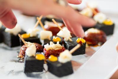 Paysage au crépuscule avec silhouettes de collines, arbres et habitations sous un ciel dégradé du bleu à l'orange.