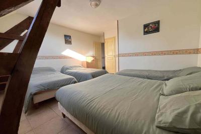 Salle de bain avec lavabo, miroir, meuble blanc et douche à paroi vitrée sur un carrelage beige.