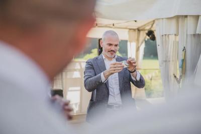 Un groupe de personnes assises et debout, riant et échangeant lors d'un moment convivial en extérieur.