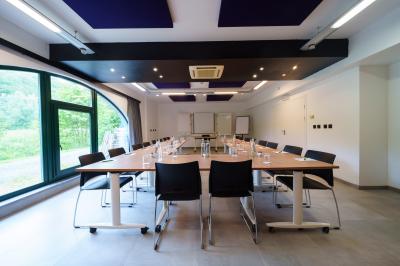 Terrasse extérieure avec tables et chaises disposées autour d’un bâtiment circulaire, vue aérienne.