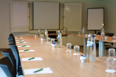 Terrasse extérieure avec tables et chaises disposées autour d’un bâtiment circulaire, vue aérienne.