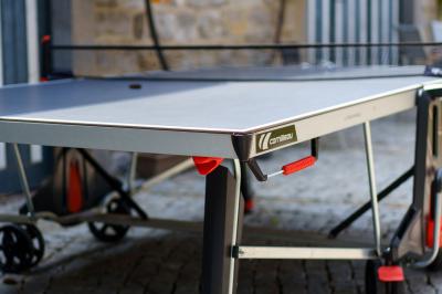 Terrasse extérieure avec tables et chaises disposées autour d’un bâtiment circulaire, vue aérienne.