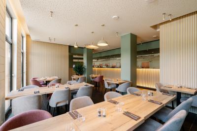 Terrasse extérieure avec tables et chaises disposées autour d’un bâtiment circulaire, vue aérienne.