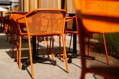 Terrasse extérieure avec tables et chaises disposées autour d’un bâtiment circulaire, vue aérienne.