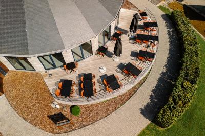 Terrasse extérieure avec tables et chaises disposées autour d’un bâtiment circulaire, vue aérienne.